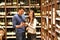 Young lucky couple shopping for red wine in the supermarket