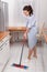 Young maid cleaning kitchen floor