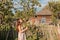 A young maiden woman in a summer retro dress in the rays of sunrise holds a branch of an apple tree in her hands and look in bliss