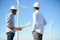 Young maintenance engineer team working in wind turbine farm at sunset stock photo