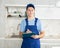 Young maintenance worker noting down cleaning tasks in home kitchen