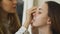 Young make-up artist makes a girl beautiful makeup for face before closeup an important event