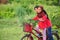 A young malay female children ride a bicycle at their hometown. Smile face from them. View a background of Malay rural village.