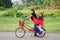 A young malay female children ride a bicycle at their hometown. View a background of Malay rural village.