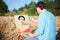 Young male artist, drawing portrait on canvas painting on wheat field in summer. Painting workshop in rural countryside. Artistic
