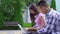 Young male asian student with book and young asian woman with laptop in park slow mo