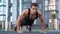 Young male athlete with a bare torso. portrait strong man engaged in push-ups on the floor, straining powerful handss