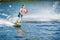 Young male athlete glides on kiteboard on the waves on the lake