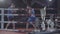 Young male attractive fighter boxer athlete training workout practicing punch hook kick with personal coach boxing ring