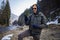 Young Male Backpacker In Winterwear Using Smartphone In Winter Forest