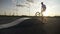 Young male biker riding on the edge of ramp in an acrobatic training at sunset slow motion -