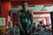 Young male bodybuilder athlete, trains in gym, using sports equipment