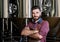 Young male brewer in leather apron at modern brewery factory