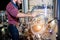 Young male brewer in leather apron supervising the process of beer fermentation at modern brewery factory