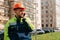 Young male builder talking on the phone with special construction clothing and a helmet