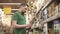 Young male buyer is holding solar-powered lamp in hand in shopping area