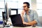 Young male call center operator working on his computer while hi