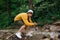 Young male cameraman with a camera on a stabilizer in his hands shoots a video of nature on a hike. Guy stands with a camera on a