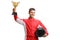 Young male car racer standing and holding a helmet and a gold trophy cup