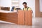 Young male carpenter repairing desk in the office