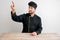 Young male chef in black uniform presses a virtual button