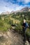 Young male climber looks up at a Via Ferrata in the Dolomites and many people stand behind him