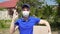 Young male courier delivery man in medical mask and gloves shows okay gesture.