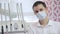 A young male dentist, disposable mask, next to dental instrument, looking right.