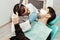 A young male dentist doctor treats a patient. Medical manipulations in dentistry, surgery. Professional uniform and