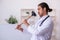 Young male doctor holding plunger in funny concept