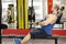 Young male doing cable row exercises with strained face, guy building muscles