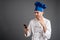 Young male dressed in a white chef suit reading and sending text messages on cellphone looking nervously