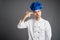 Young male dressed in a white chef suit showing shot head gesture