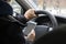 Young male driver uses mobile phone while driving car