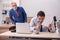 Young male employee and old boss burning papers at workplace