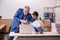 Young male employee and old boss burning papers at workplace