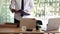 Young male employee standing near work table putting his stuff from in carton box belongings after being dismissed resignation