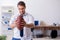 Young male employee throwing rugby ball in the office