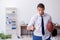 Young male employee throwing rugby ball in the office