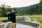 Young male explorer enjoying the view of the river in wilderness