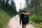 Young male explorer walking on the dirt road through the forest