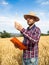 Young male farmer observes the wheat harvest. Ecological agriculture.