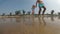 A young male father runs with a baby girl on a wet beach. Family at the sea