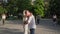 young male and female couple in love hug each other background of people in park