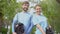 Young male and female volunteers smiling camera holding trees saplings, ecology