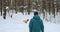 a young male freelancer in a blue jacket who walks with a dog in a snowy forest