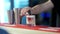 Young male hand pouring red liquor from jigger in glass with cocktail. Unrecognizable Caucasian bartender mixing