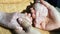 A young male hands comforting an elderly pair of hands of grandma outdoor close up.