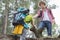 Young male hiker helping woman in climbing cliff at forest