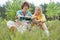 Young male hiker pouring coffee for woman while relaxing in field